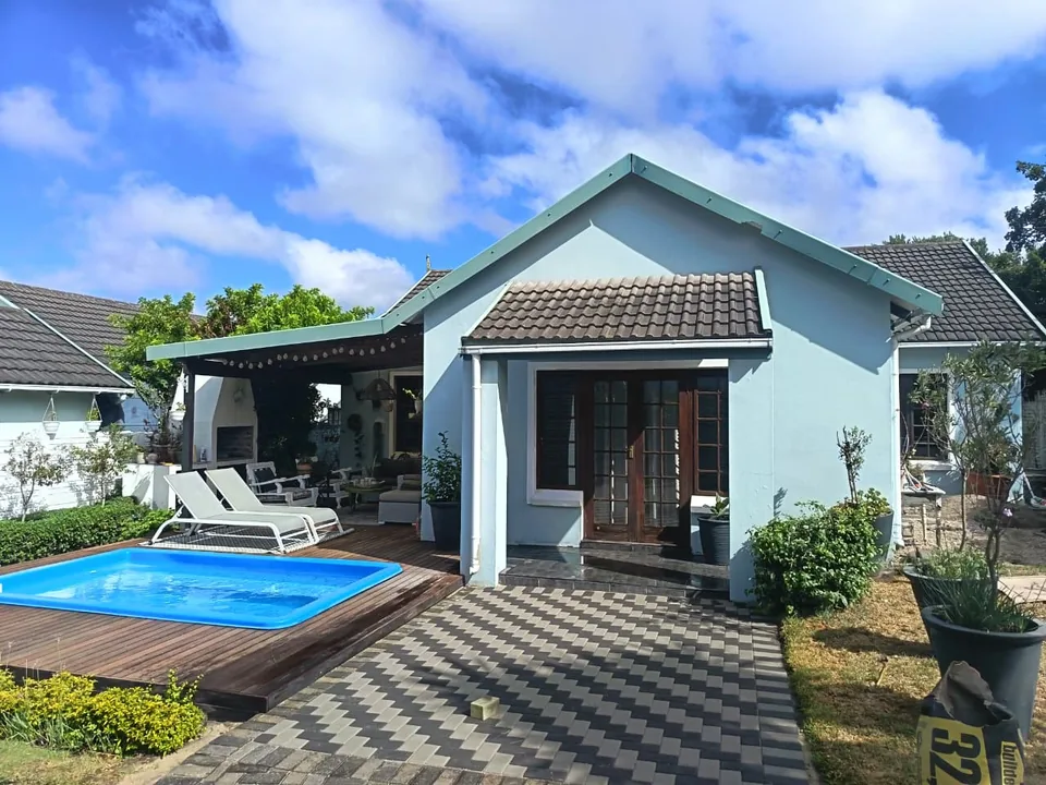 Two-tone checkerboard patio paving around a backyard pool in Gqeberha